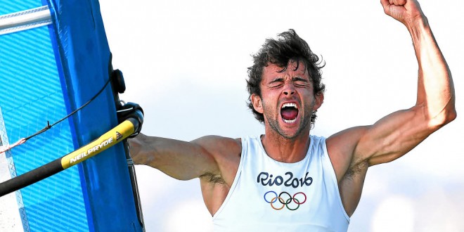 France's Pierre Le Coq celebrates after taking the third place in the RS:X Men sailing final race on Guanabara Bay in Rio de Janerio during the Rio 2016 Olympic Games on August 14, 2016. / AFP / WILLIAM WEST